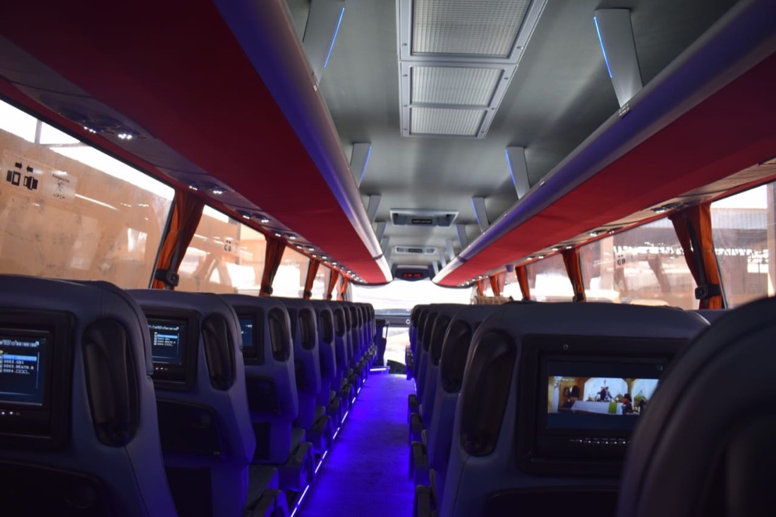 Super Jet coach interior with seatback screens and blue aisle lighting