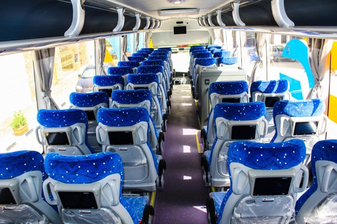 East Delta coach interior with blue seats and seatback screens
