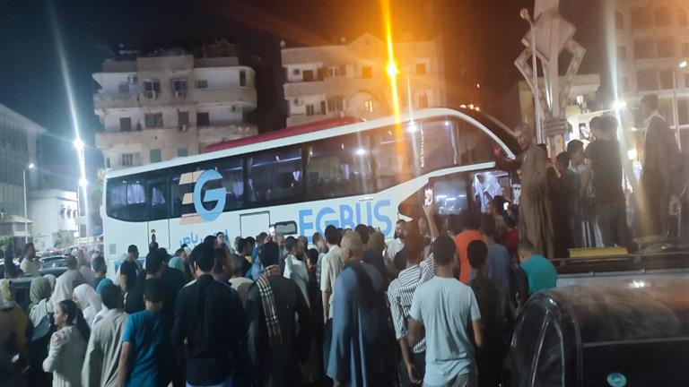 Passengers boarding an EG Bus coach at night