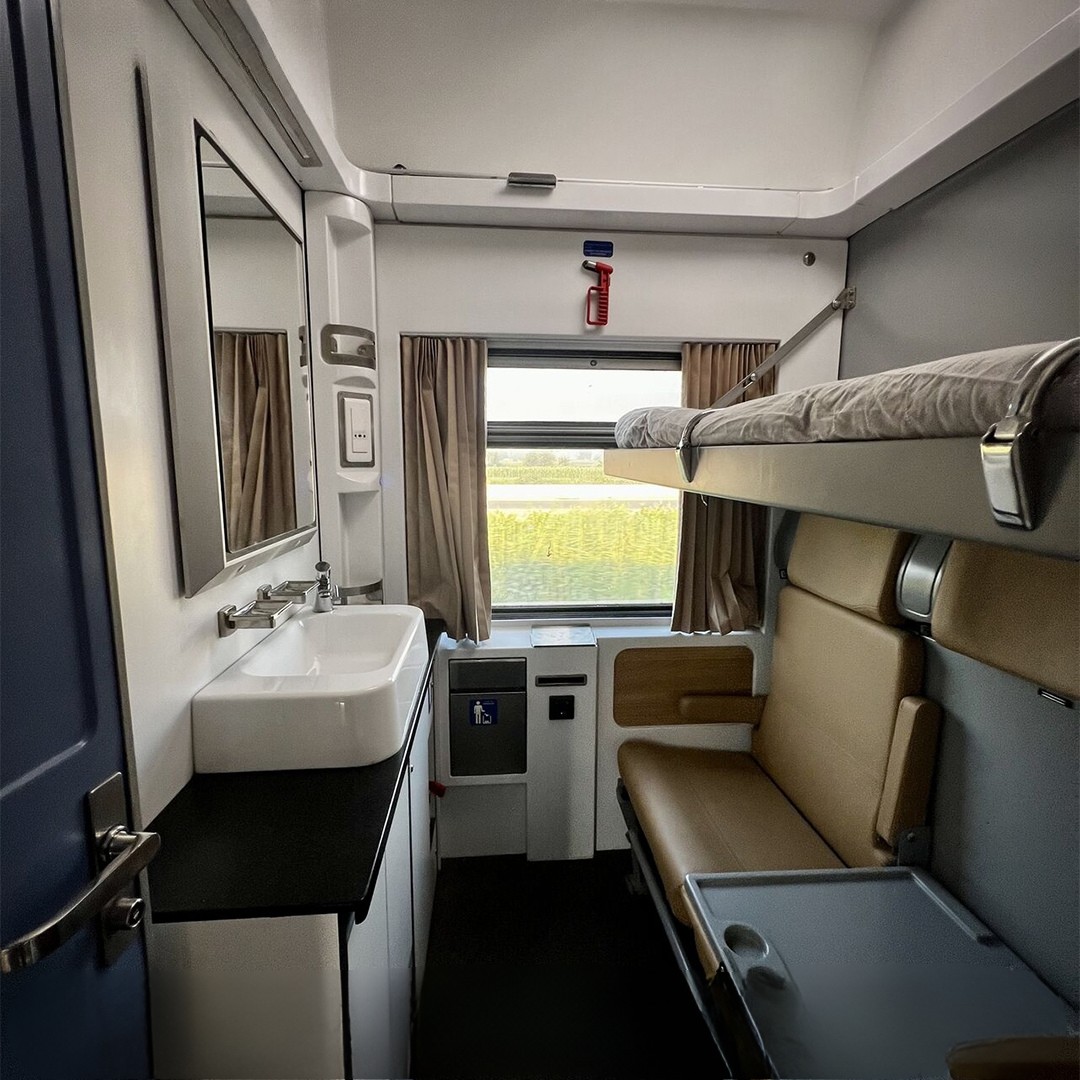 Private sleeper train cabin in Egypt with seats, upper berth and window